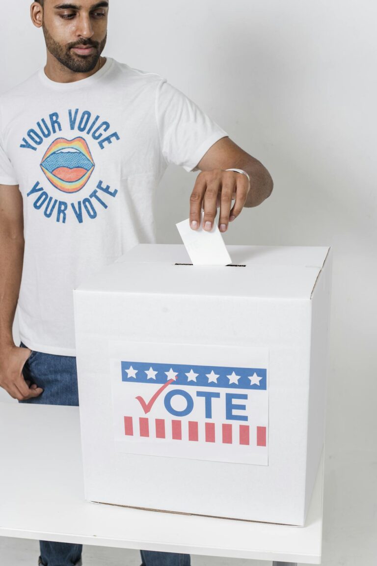 A young man casting his vote at a ballot box, highlighting democratic participation.